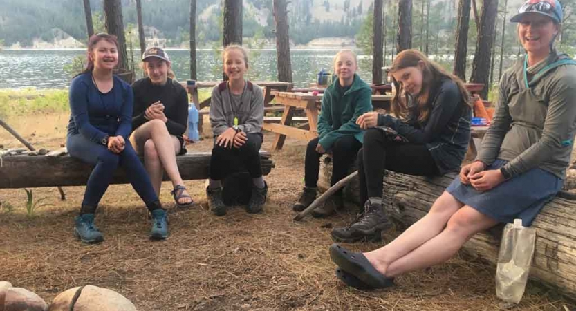 a group of outward bound students rest at a campsite in washington state